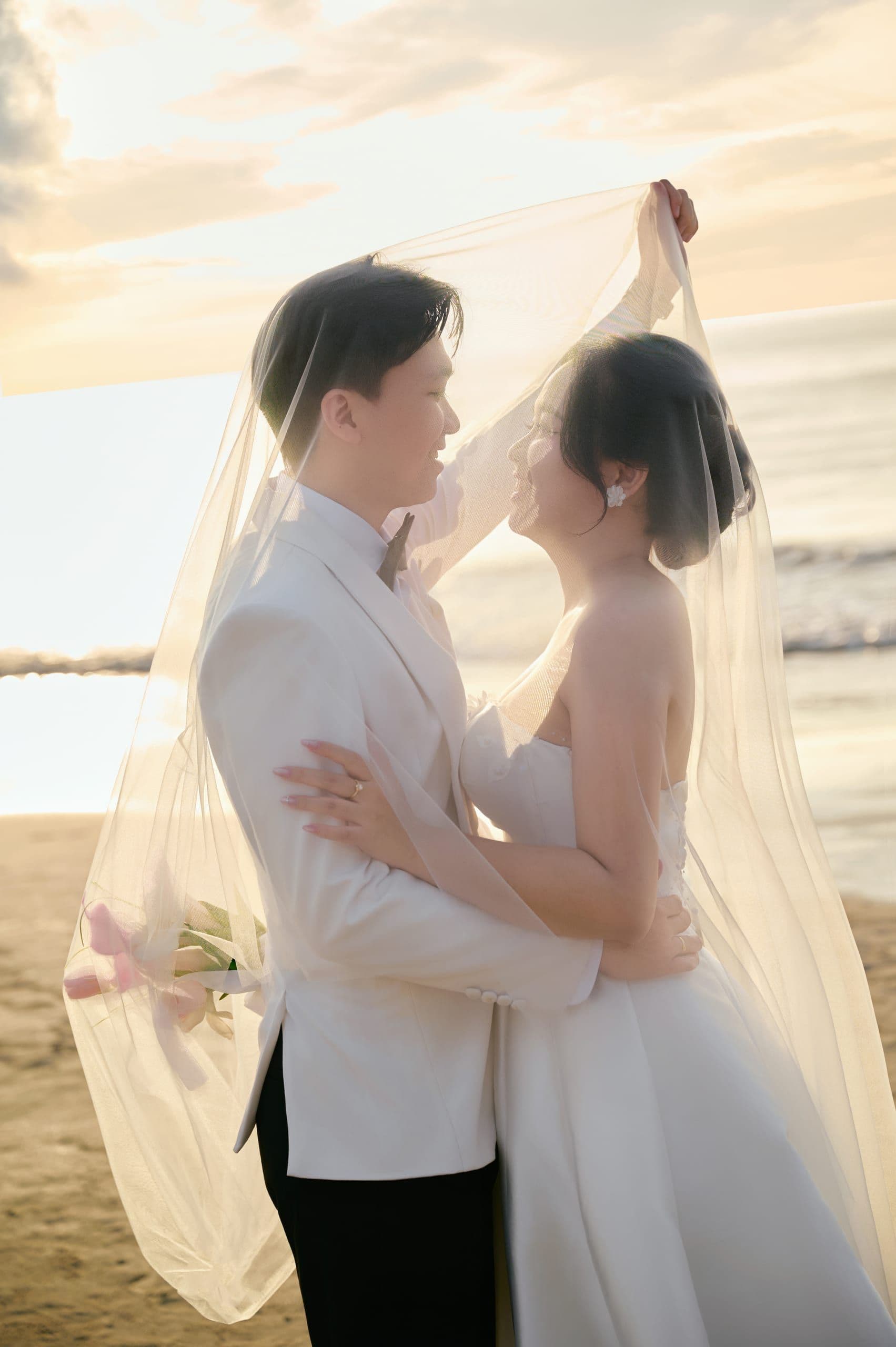 Chú rể cúi hôn cô dâu tại bãi biển